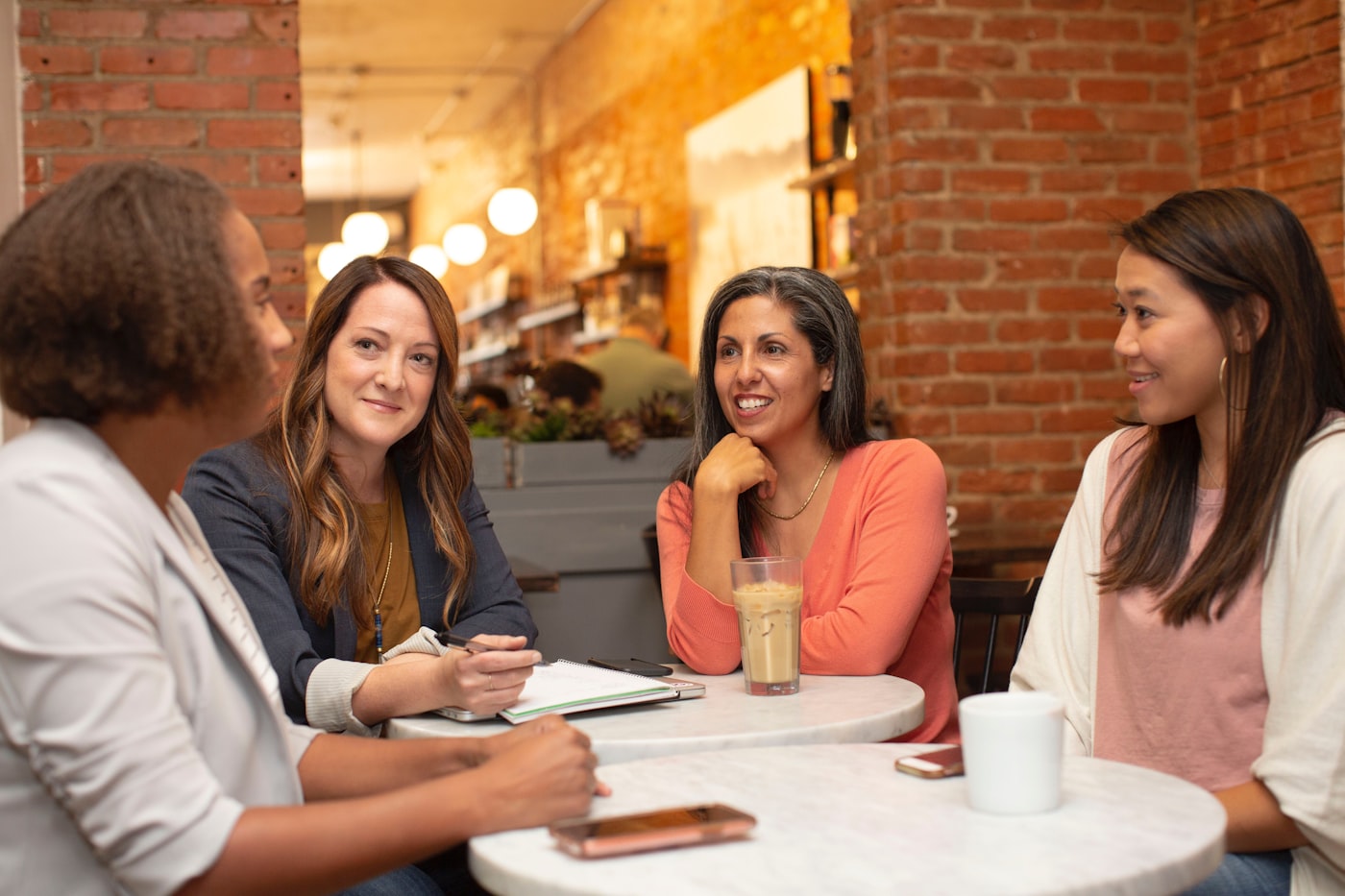 A diverse group of people talking at a cafe table